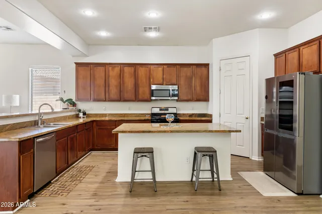 a kitchen with stainless steel appliances granite countertop a sink refrigerator and microwave