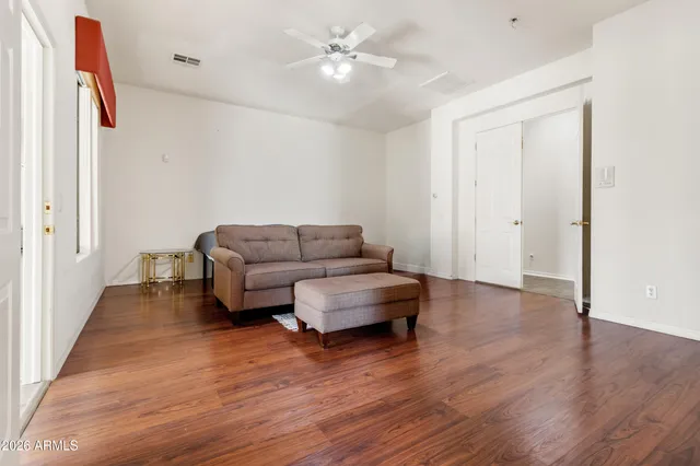 a living room with furniture and a ceiling fan