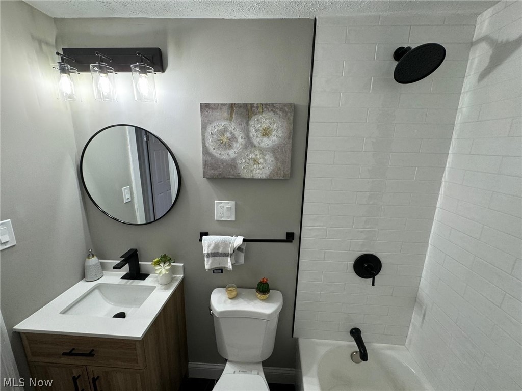 3356 Berea Road Cleveland, OH 44111 - Photo 18 of 35 Full bathroom with tiled shower / bath, vanity, toilet, and a textured ceiling