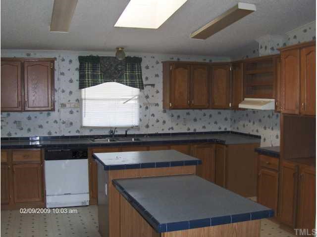 29 Charlie Winstead Road Roxboro, NC 27574 - Photo 2 of 4 a kitchen with granite countertop a sink stove and cabinets