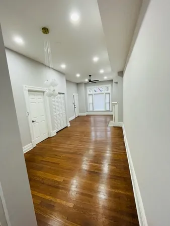 a view of an empty room with wooden floor