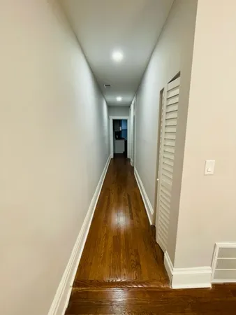 a view of a hallway with wooden floor