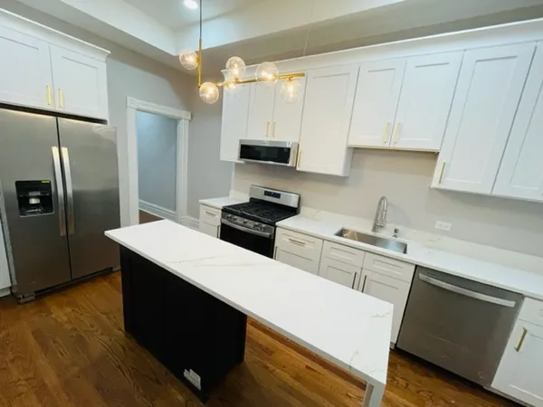 a kitchen with white cabinets and stainless steel appliances