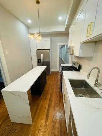 a kitchen with a sink a counter space cabinets and appliances