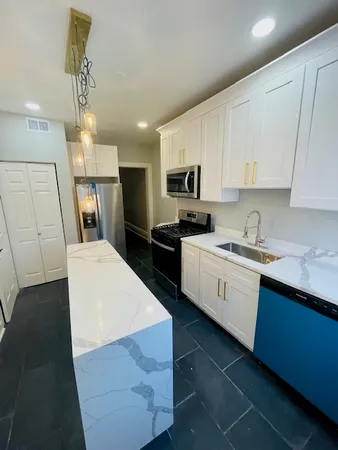 a kitchen with a sink a counter top space stainless steel appliances and cabinets