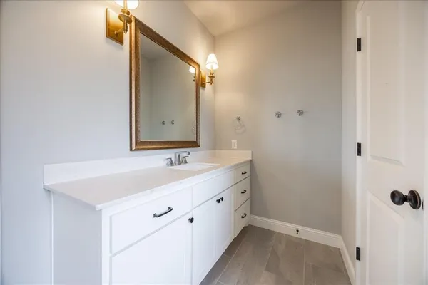 a spacious bathroom with a double vanity sink a mirror and shower