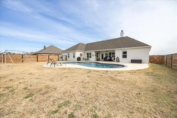 a view of a house with swimming pool and sitting area