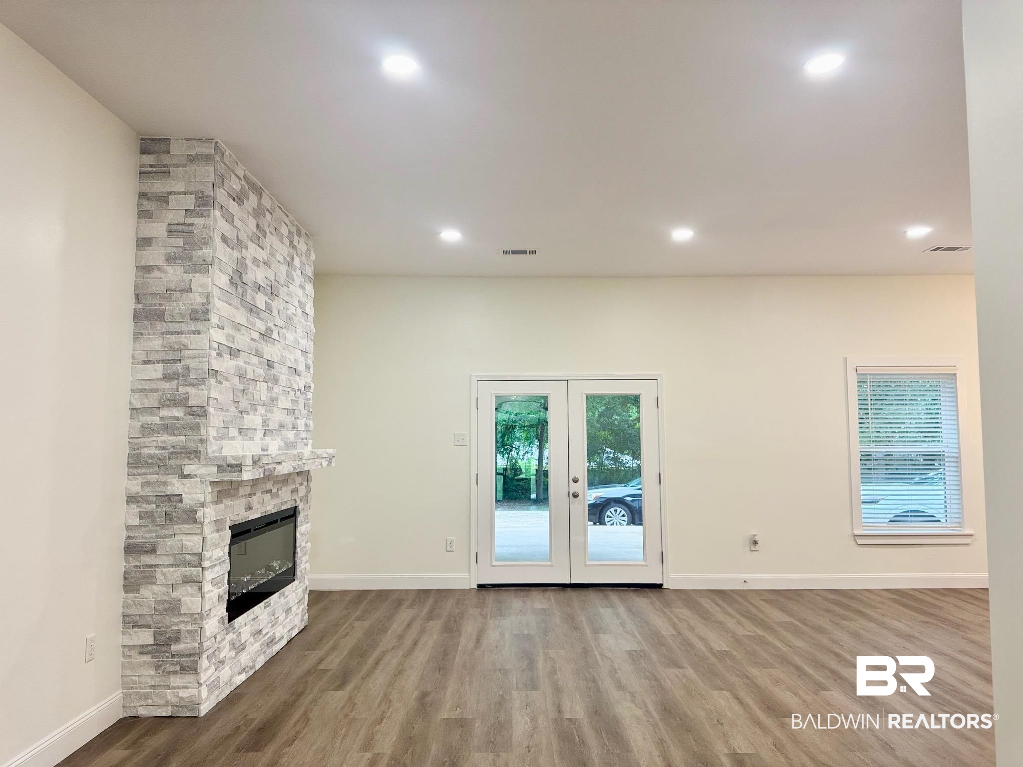 2663 Demetropolis Road Mobile, AL 36693 - Photo 6 of 26 Unfurnished living room featuring wood finished floors, a fireplace, french doors, and recessed lighting