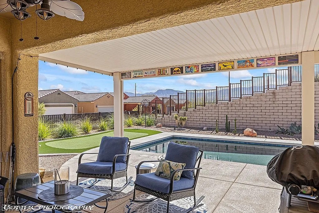 1304 Cottage Ridge Mesquite, NV 89034 - Photo 28 of 52 An inviting covered patio offers a refreshing pool and an artificial turf putting green for leisure.
