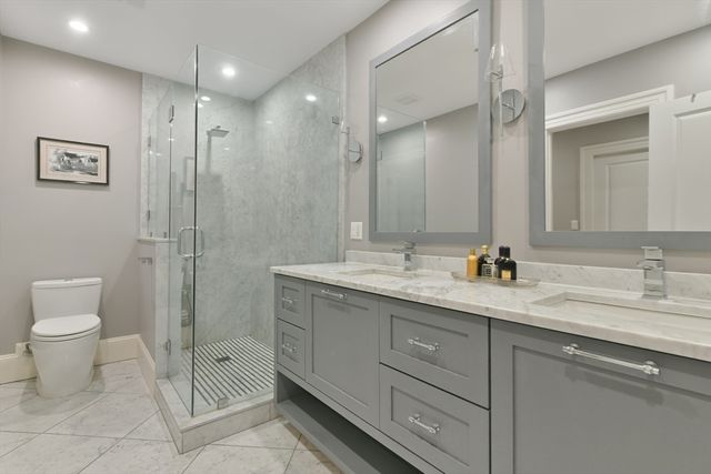 a bathroom with a toilet a shower a sink and mirror