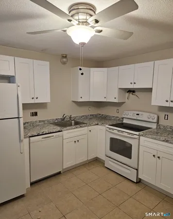 a kitchen with granite countertop cabinets stainless steel appliances and a counter space