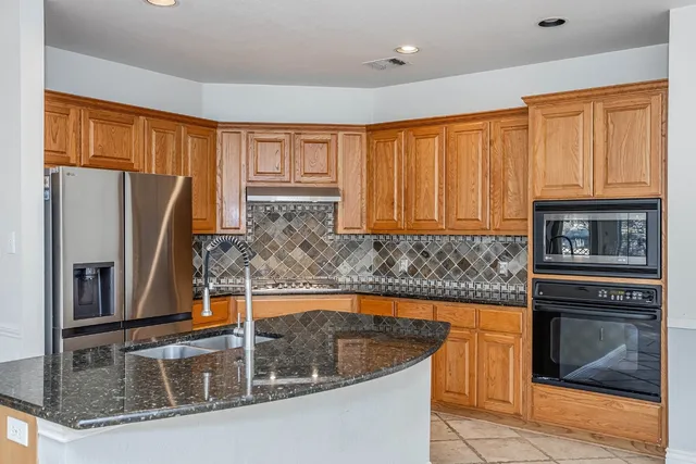 a kitchen with stainless steel appliances granite countertop a sink a window and a counter space
