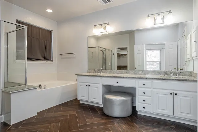 a view of a bathroom with wooden floor fridge and a sink