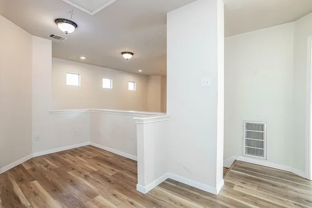 a view of staircase with railing and white walls