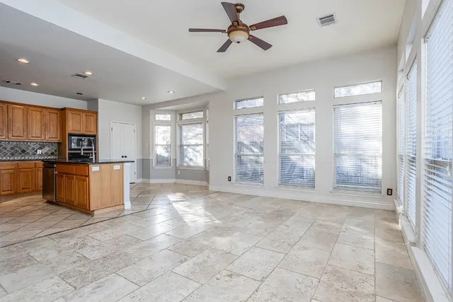 a view of kitchen with stainless steel appliances granite countertop a stove a sink dishwasher a refrigerator and a dining table with wooden floor