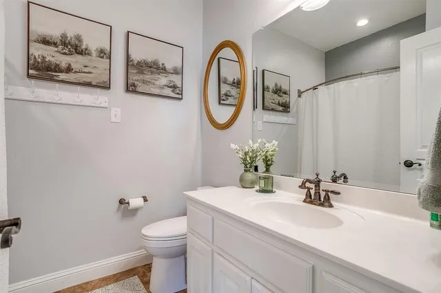 a bathroom with a toilet a sink and a mirror