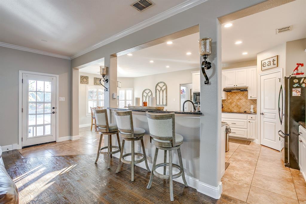 1249 Handkerchief Way Fort Worth, TX 76052 - Photo 7 of 40 a room with stainless steel appliances kitchen island granite countertop a refrigerator a stove a dining table and chairs with wooden floor