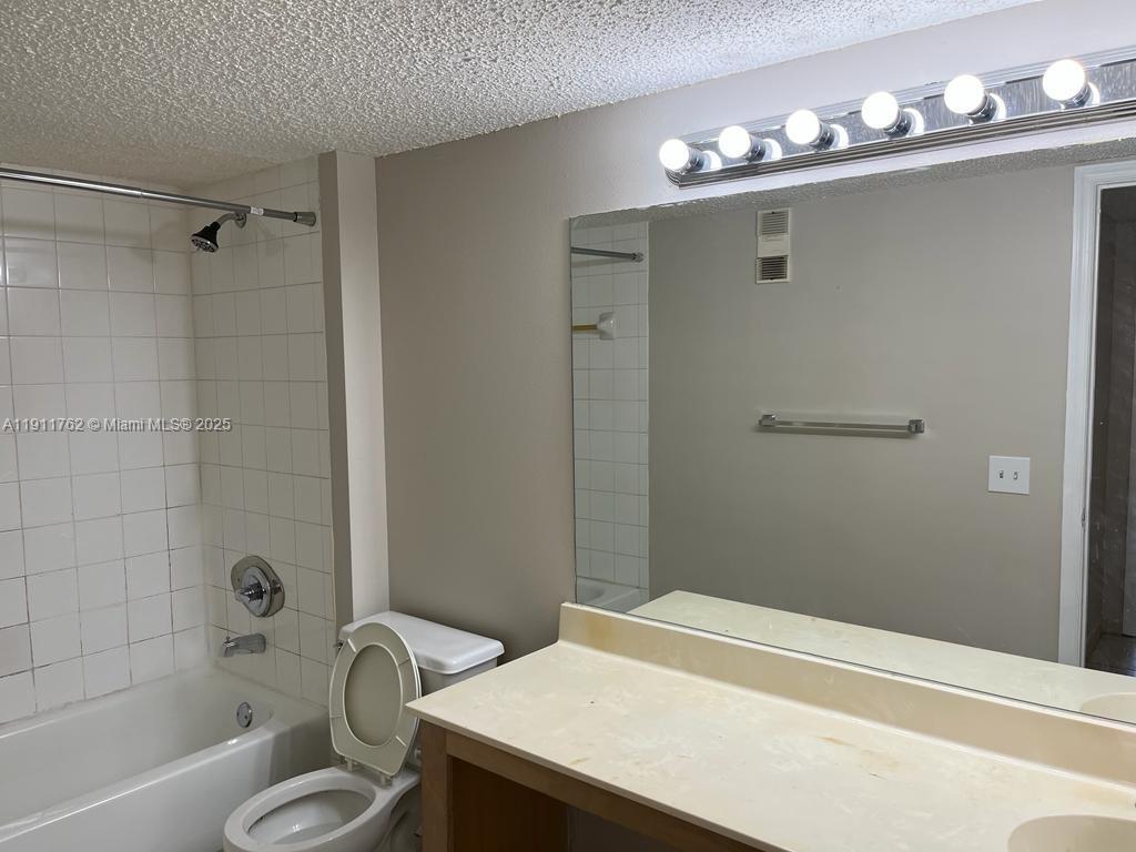 4015 West McNab Road, Unit D308 Pompano Beach, FL 33069 - Photo 11 of 17 a bathroom with a sink a toilet and shower