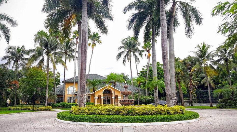 4015 West McNab Road, Unit D308 Pompano Beach, FL 33069 - Photo 14 of 17 a front view of a house with a yard and palm trees