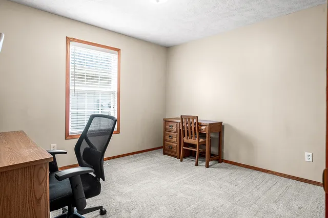 a view of a workspace with furniture and a window