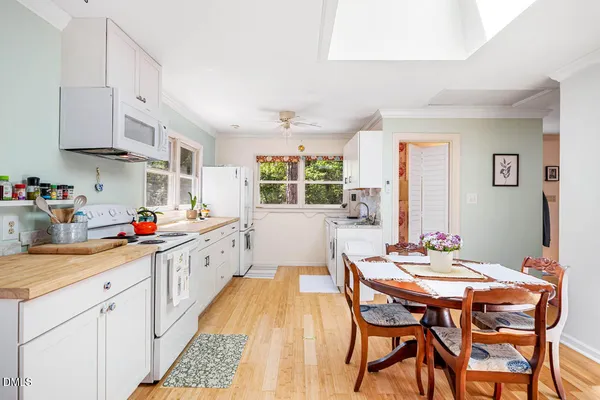 a kitchen with stainless steel appliances kitchen island a table and chairs in it
