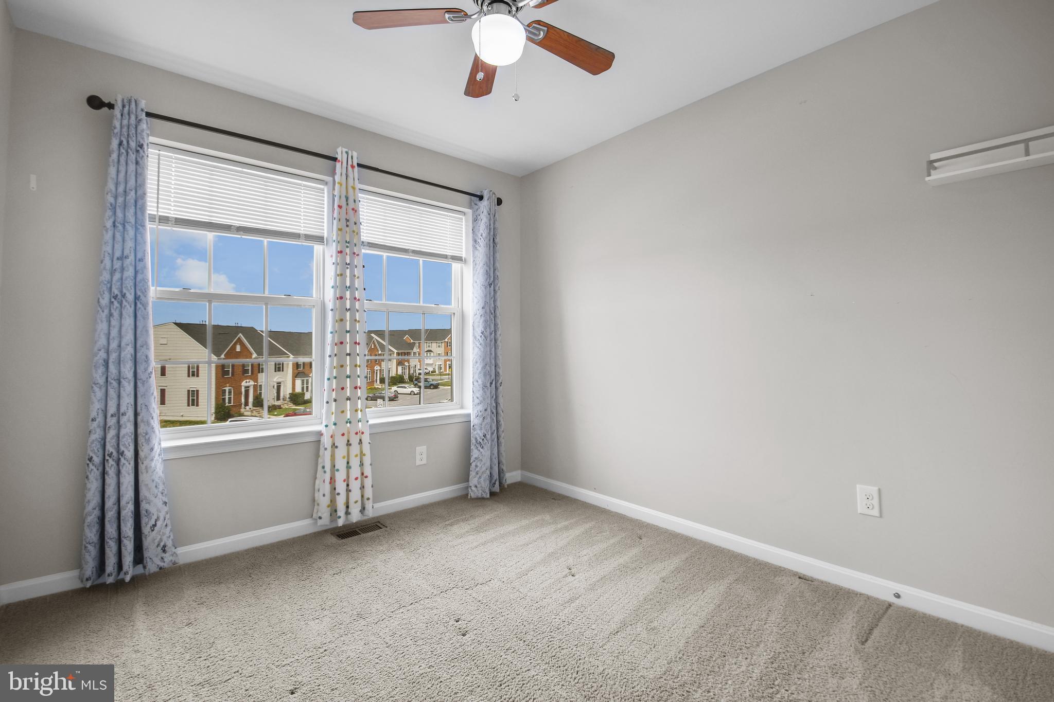 4648 Cambria Road Frederick, MD 21703 - Photo 16 of 22 an empty room with a fireplace and windows