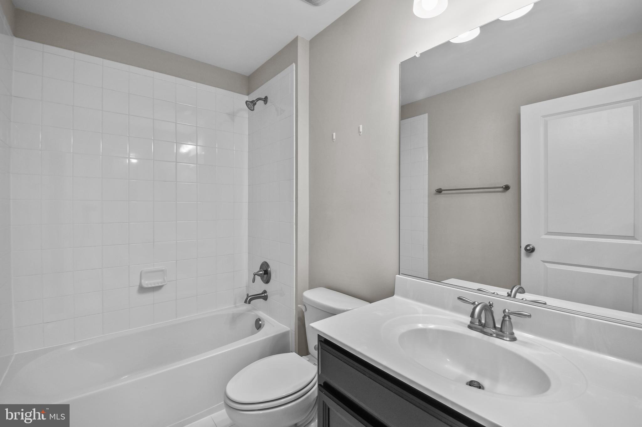 4648 Cambria Road Frederick, MD 21703 - Photo 17 of 22 a bathroom with a bathtub shower sink vanity mirror and toilet