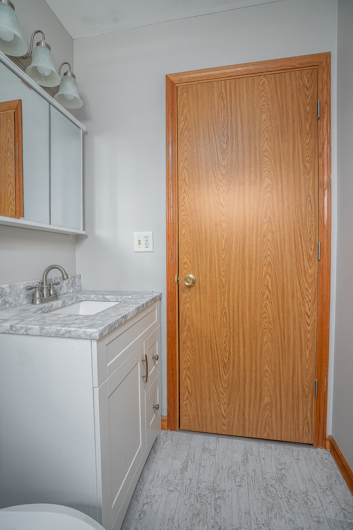4905 50th Street Moline, IL 61265 - Photo 17 of 25 a bathroom with a granite countertop sink and a mirror