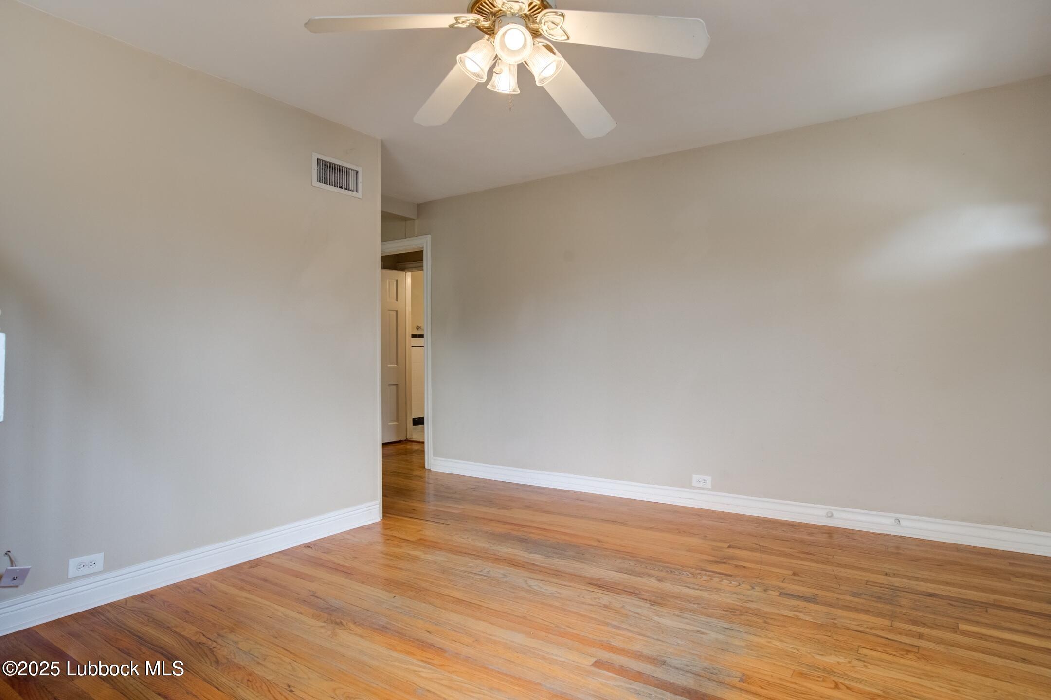 2308 28th Street Lubbock, TX 79411 - Photo 12 of 21 wooden floor in an empty room with a window