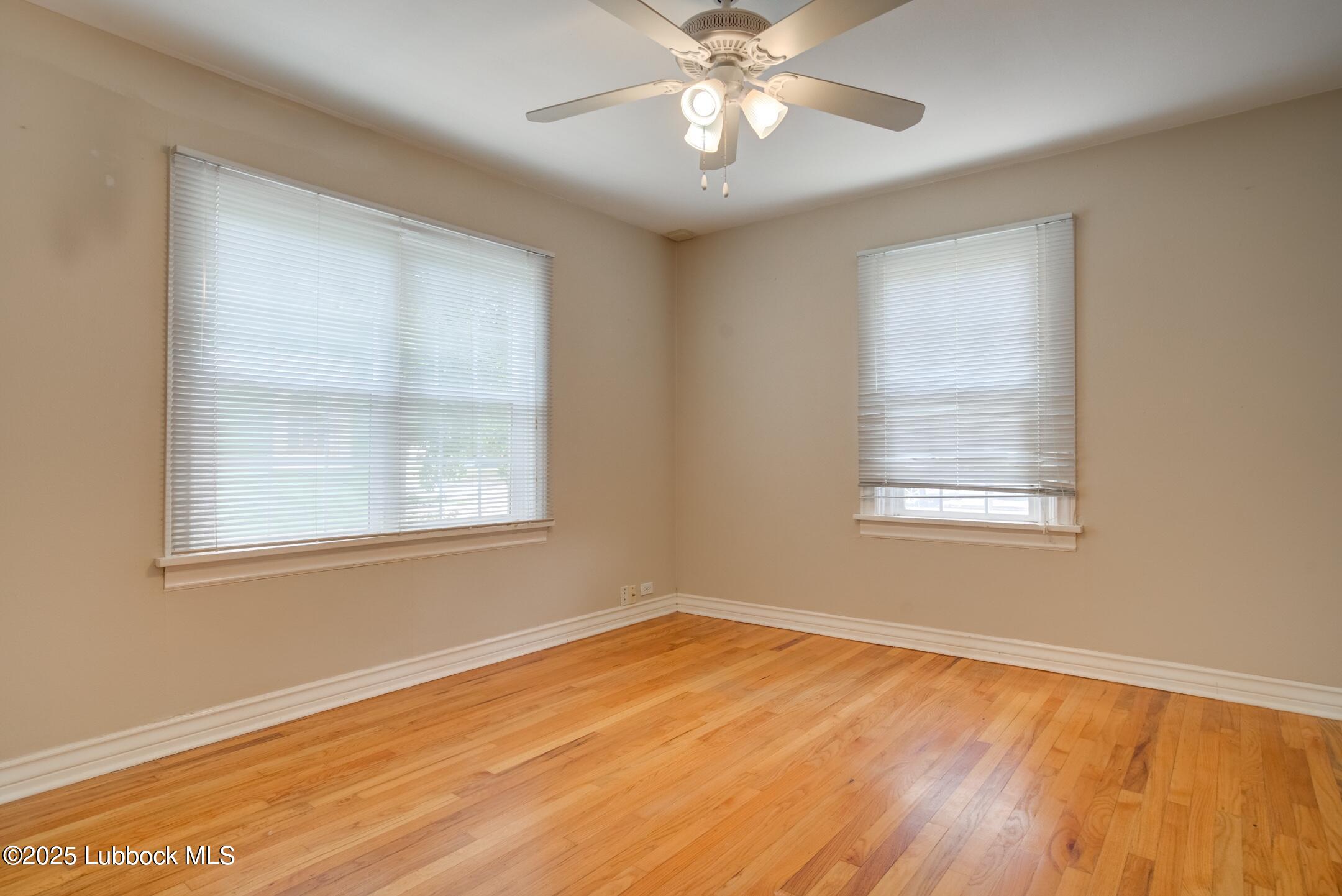 2308 28th Street Lubbock, TX 79411 - Photo 13 of 21 a view of an empty room with wooden floor and a window