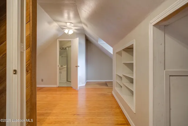 a view of a hallway with wooden floor and closet