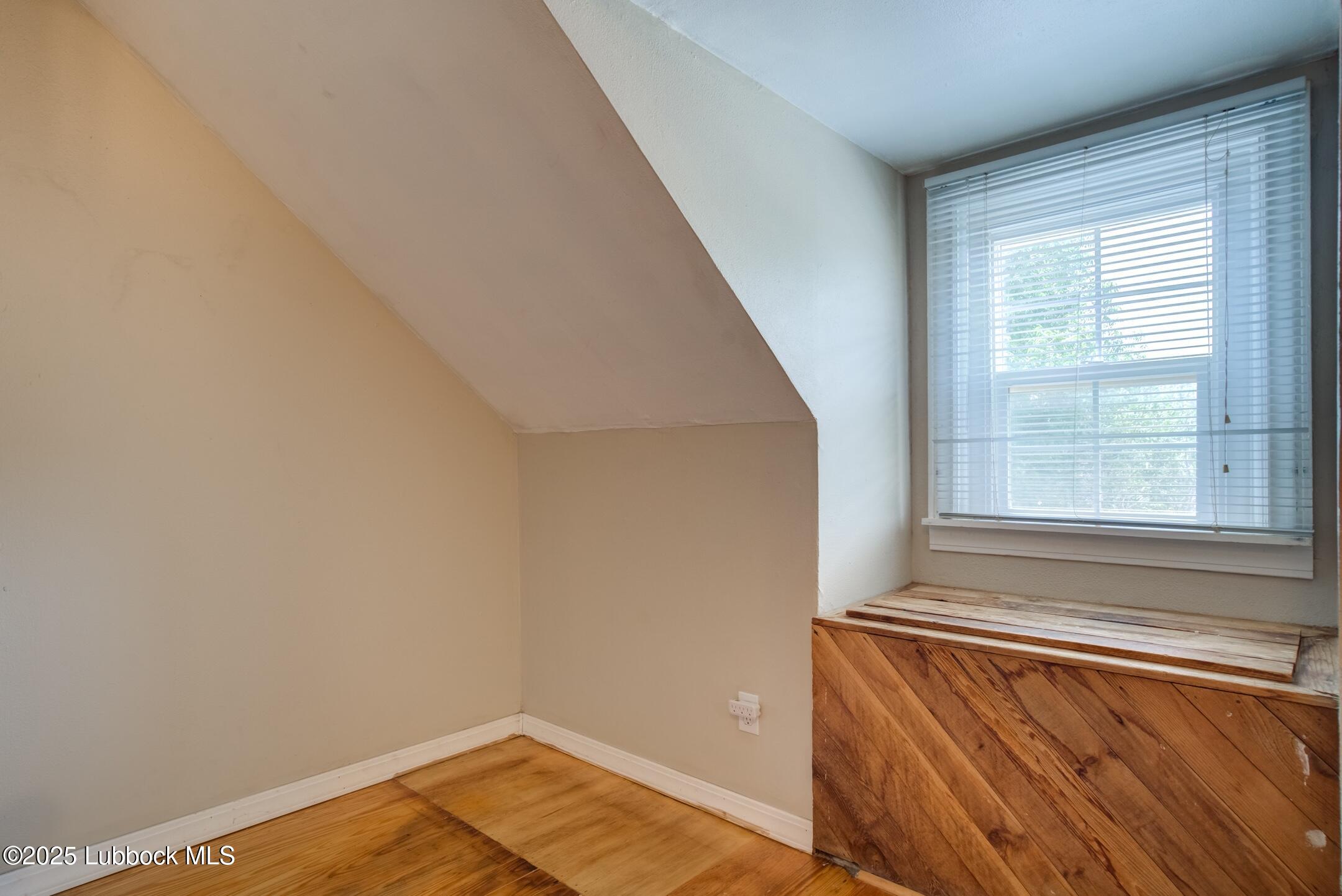 2308 28th Street Lubbock, TX 79411 - Photo 19 of 21 a view of an empty room with wooden floor and a window