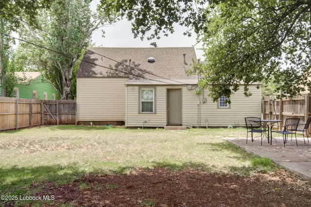 a backyard of a house with table and chairs