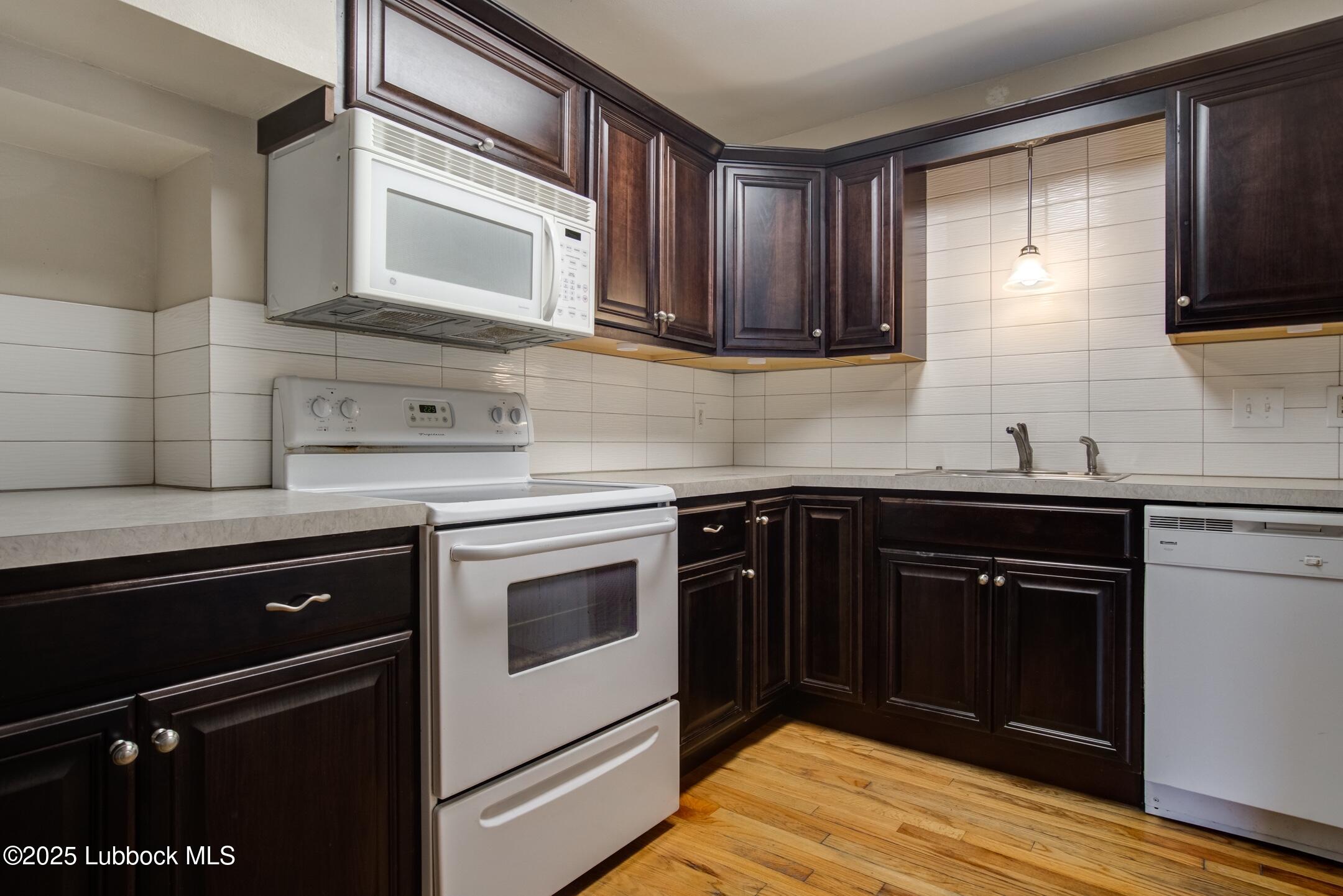 2308 28th Street Lubbock, TX 79411 - Photo 4 of 21 a kitchen with granite countertop cabinets stainless steel appliances and a sink