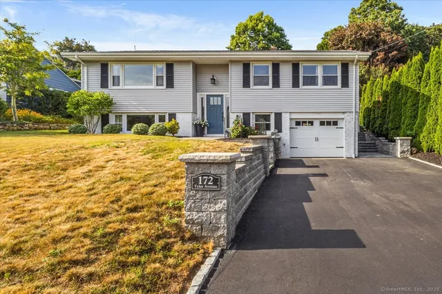 a front view of a house with yard and trees