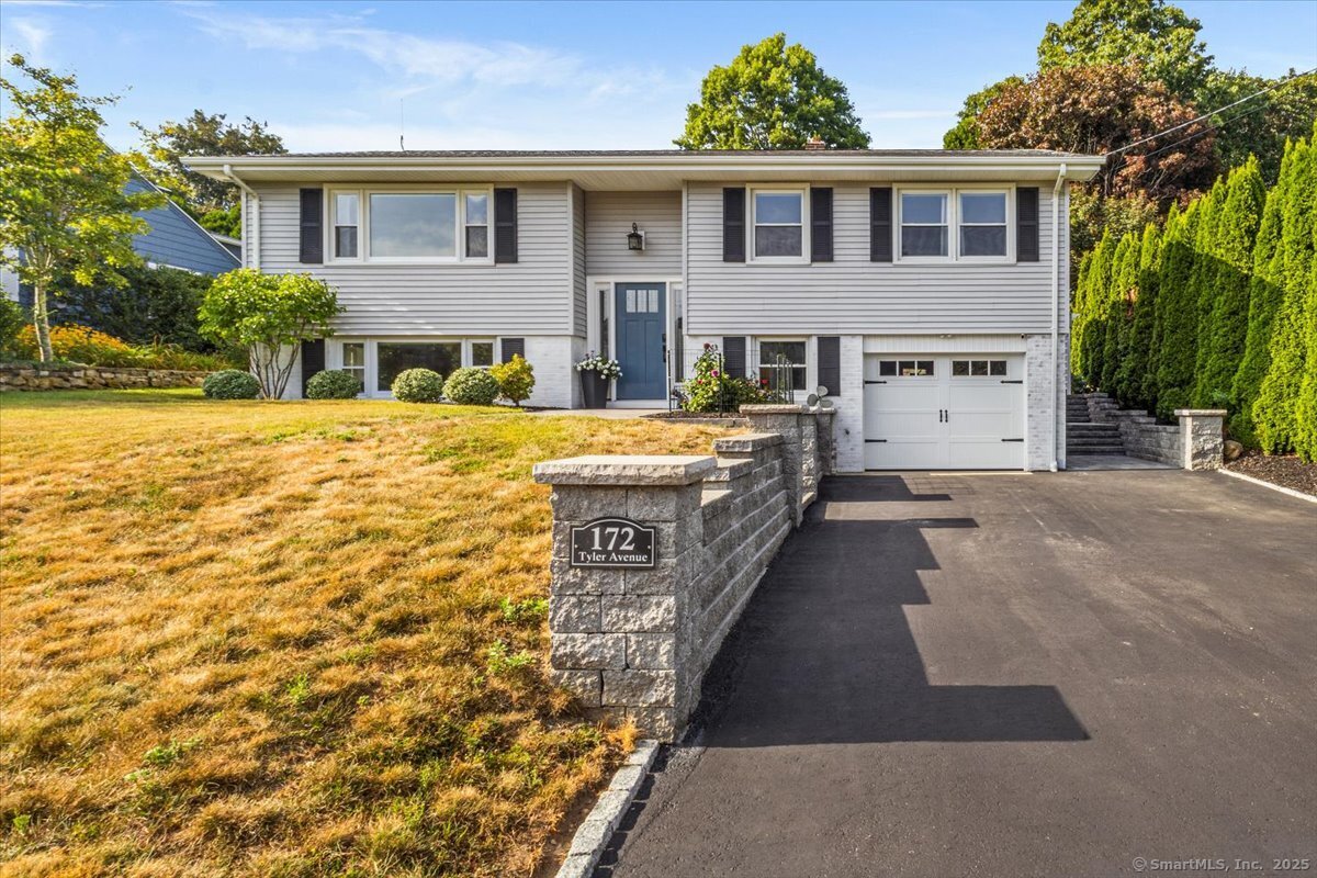 a front view of a house with yard and trees