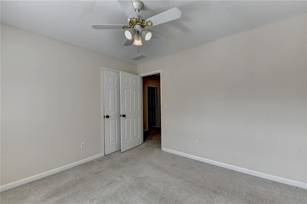 100 Hawnley Trc Northwest Suwanee, GA 30024 - Photo 47 of 58 an empty room with a chandelier fan and a ceiling fan