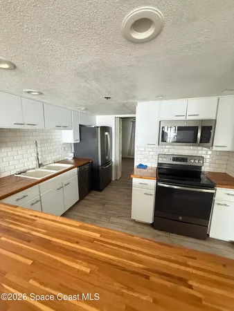 a kitchen with a stove a sink and a refrigerator