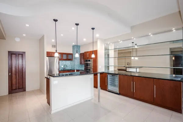 a kitchen with stainless steel appliances granite countertop a sink a stove and a refrigerator