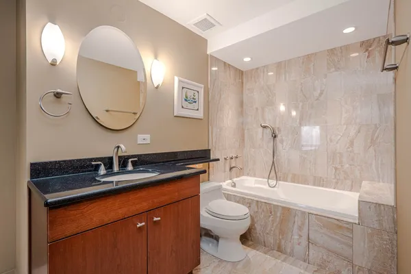 a bathroom with a double vanity sink mirror and toilet