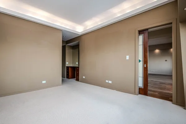 a view of an empty room with closet and wooden door