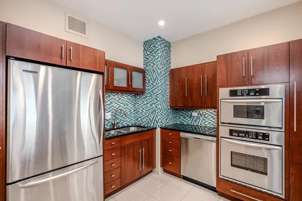 a kitchen with granite countertop a refrigerator stove and microwave