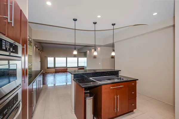 a kitchen with stainless steel appliances granite countertop a stove a sink and a refrigerator