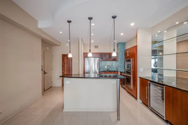 a kitchen with stainless steel appliances granite countertop a refrigerator a oven and a sink