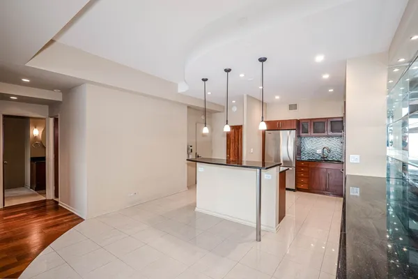 a open kitchen with stainless steel appliances kitchen island granite countertop a refrigerator and stove