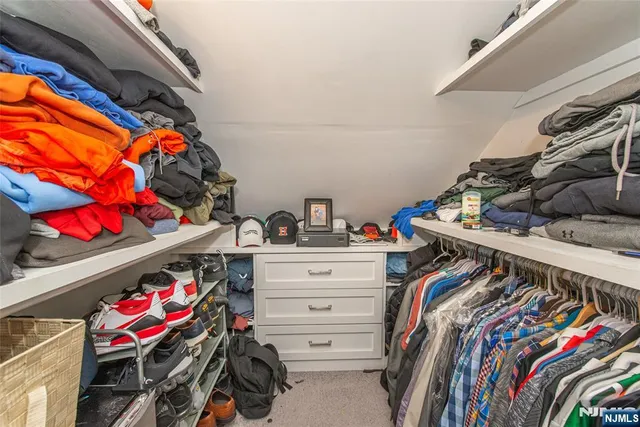a view of walk in closet with clothes and shoes