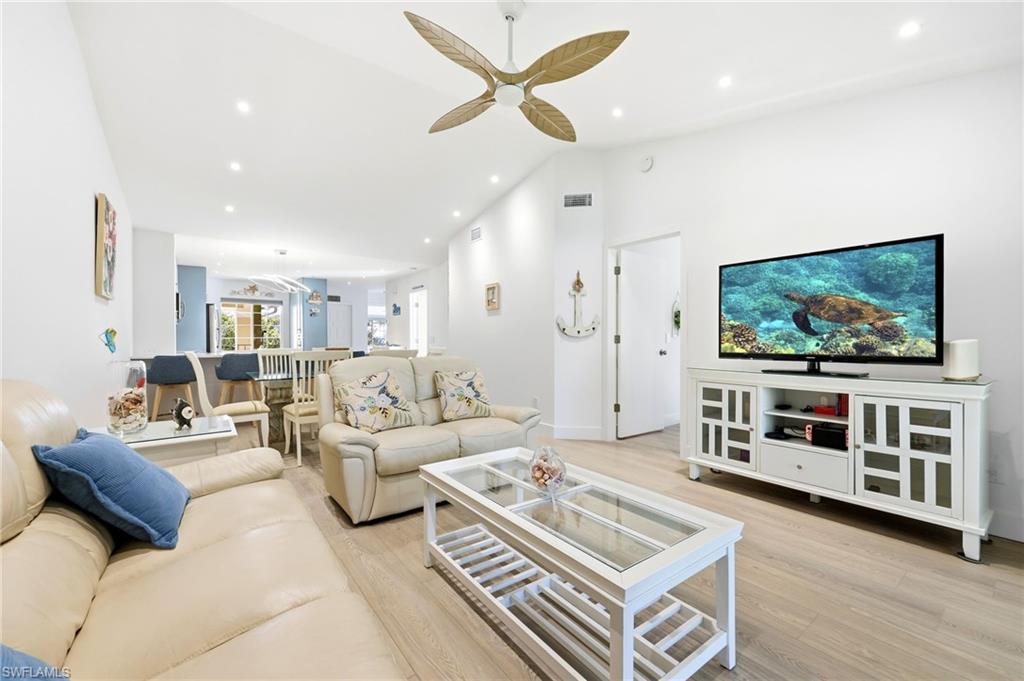 7707 Jewel Lane, Unit 201 Naples, FL 34109 - Photo 17 of 31 Living area with light wood finished floors, high vaulted ceiling, recessed lighting, and ceiling fan