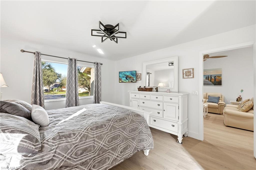 7707 Jewel Lane, Unit 201 Naples, FL 34109 - Photo 21 of 31 Bedroom with light wood-style floors and baseboards