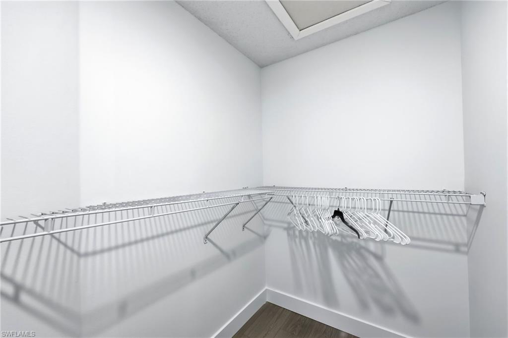 7707 Jewel Lane, Unit 201 Naples, FL 34109 - Photo 24 of 31 Walk in closet with dark wood-type flooring