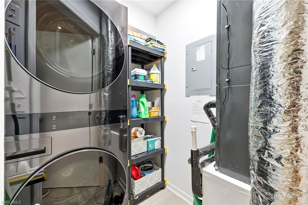 7707 Jewel Lane, Unit 201 Naples, FL 34109 - Photo 27 of 31 Laundry room featuring electric panel, estacked washer and dryer, and heating unit